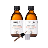 Two bottles of Anti-Flam Tonic with a tonic pourer and a 20ml plastic measuring cup on a white background.