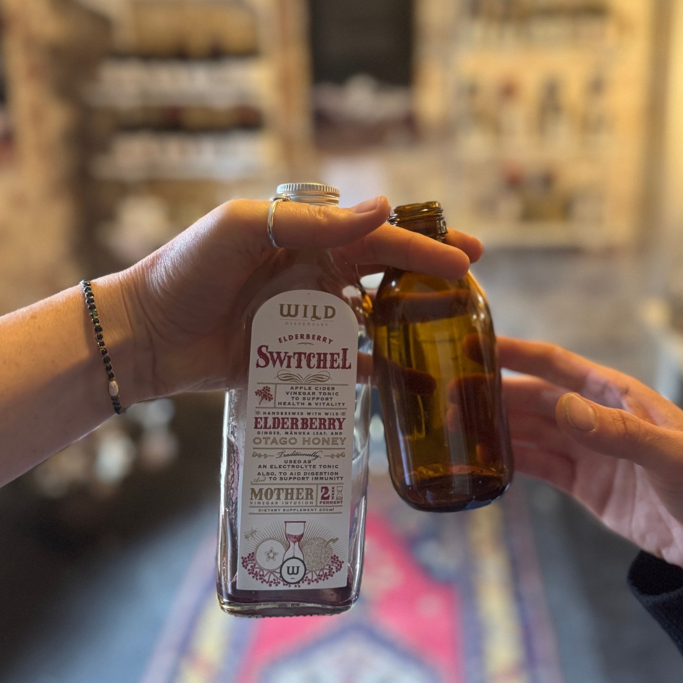 Close up of a hand passing over two empty glass bottles to another hand.