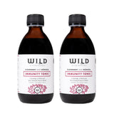 Two amber glass bottles of elderberry and mânuka Immunity Tonic with black caps and white labels, shown side by side on a white background.